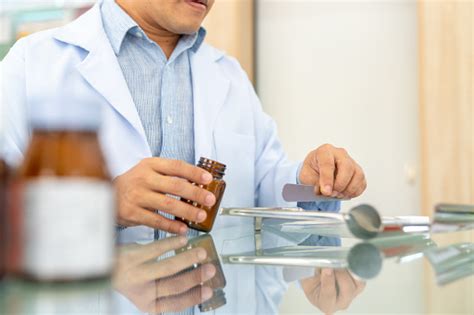 Apoteker Pria Asia Menghitung Pil Obat Pada Nampan Penghitungan Di