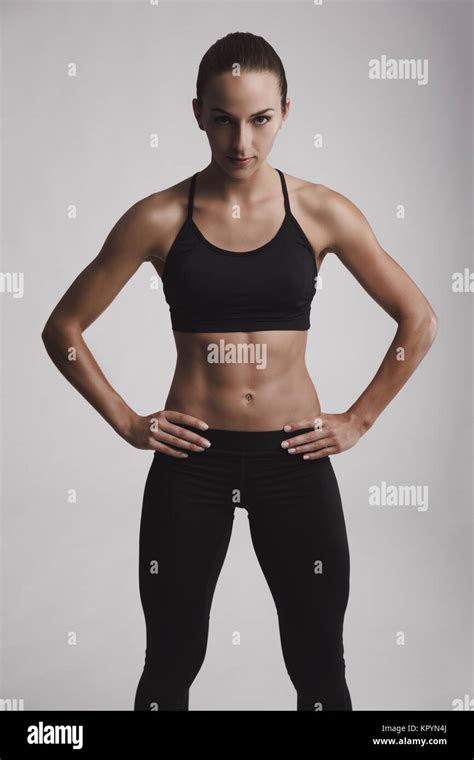 Portrait Of Sporty Young Woman With Muscular Body Looking At Camera