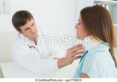 Doctor Examining A Patients Neck In Medical Office Side View Of A