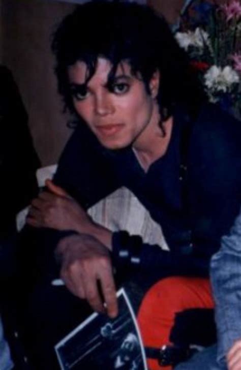 Michael Jackson Is Sitting On The Couch With His Hand In His Pocket And