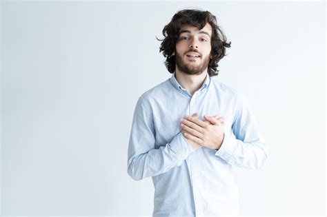 Free Photo Thankful Dark Haired Man Keeping Hands On Chest