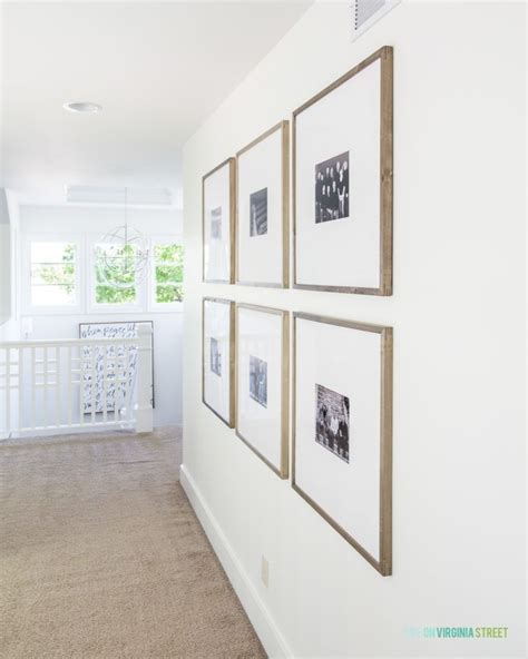 An Oversized Photo Gallery Wall In A Long Hallway Leading To A