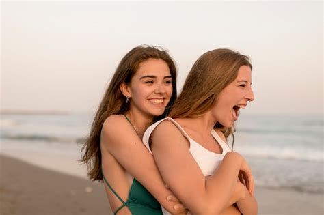 Close Up Of Two Female Friends Hugging From Behind At Beach Photo Free Download