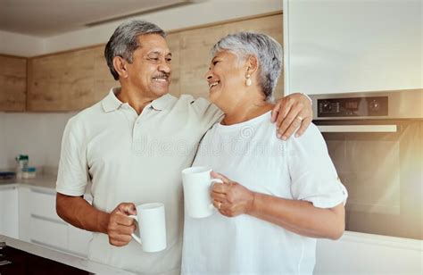 Mixed Race Senior Couple Enjoying Coffee In The Morning At Home Smiling Elderly Husband And