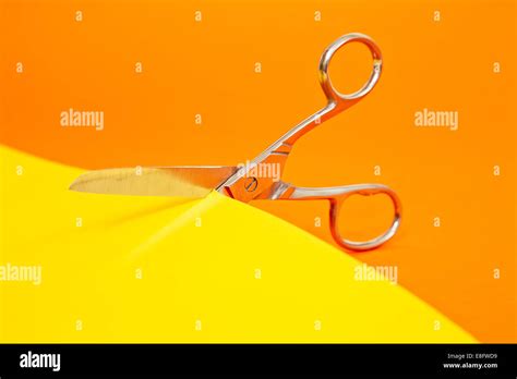 Scissors Cutting Yellow Paper Stock Photo Alamy