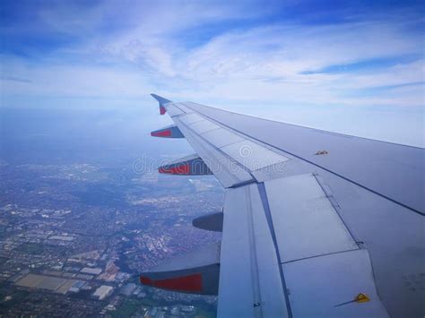 A Left Aircraft Wing Flying On The Sky Above The City Stock Image