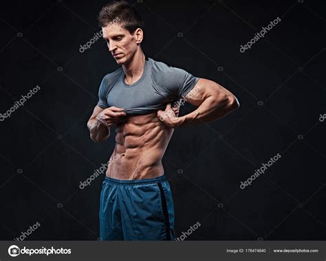 Studio Portrait Ectomorph Muscle Shirtless Male Takes Shirt Shows