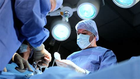 Doctor Wearing Protective Clothing Performing Surgery Using Sterilised