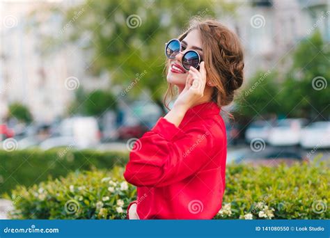 Close Up Portrait Of Pretty Girl In Sunglasses Posing To The Camera In Park She Wears Red