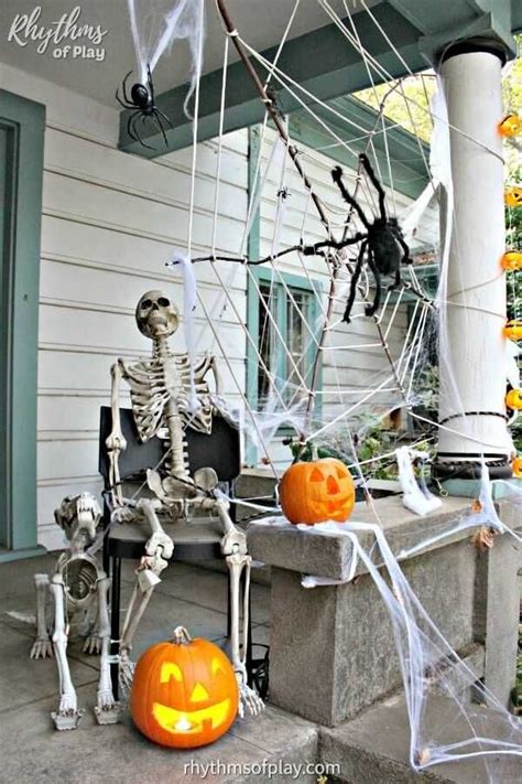 A Porch Decorated For Halloween With Skeletons And Pumpkins