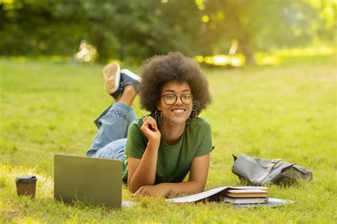 Black Student Girl Studying Outdoors With Laptop And Workbooks Lying