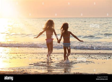 Two Sisters In Beautiful Swimsuits Running Holding Hands By The Sea Stock Photo Alamy