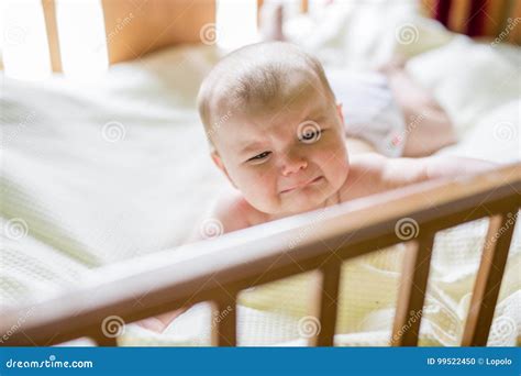 Close Up Portrait Of A Crying Cute Baby In The Crib At Home Stock Photo