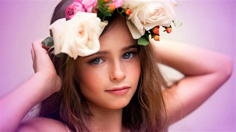Cute Girl Is Having Flowers Crown On Head Facing One Side In A Pink