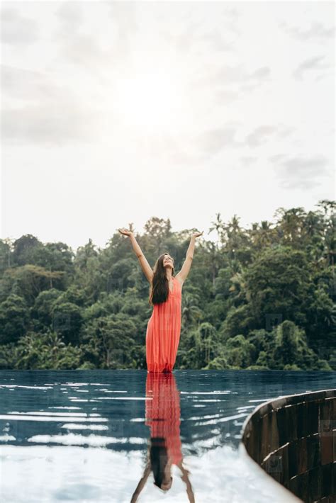 Woman In Infinity Pool With Her Hands Raised Stock Photo 265312