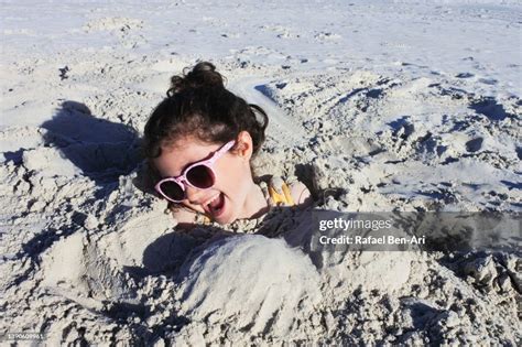 Young Girl Is Buried Up To Her Head In Sand At The Beach High Res Stock