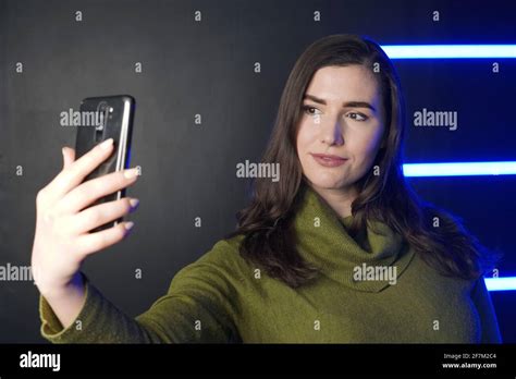 Girl Takes Selfie On Phone Against Background With Neon Lights Stock