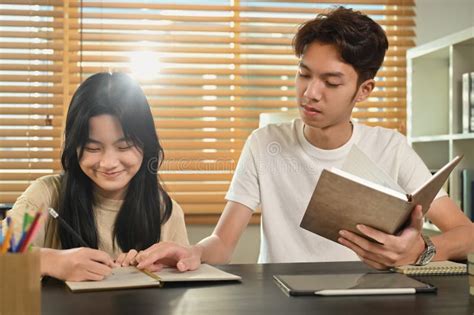 Tutor Helping Teenage Asian Girl Doing Assignments Giving Private