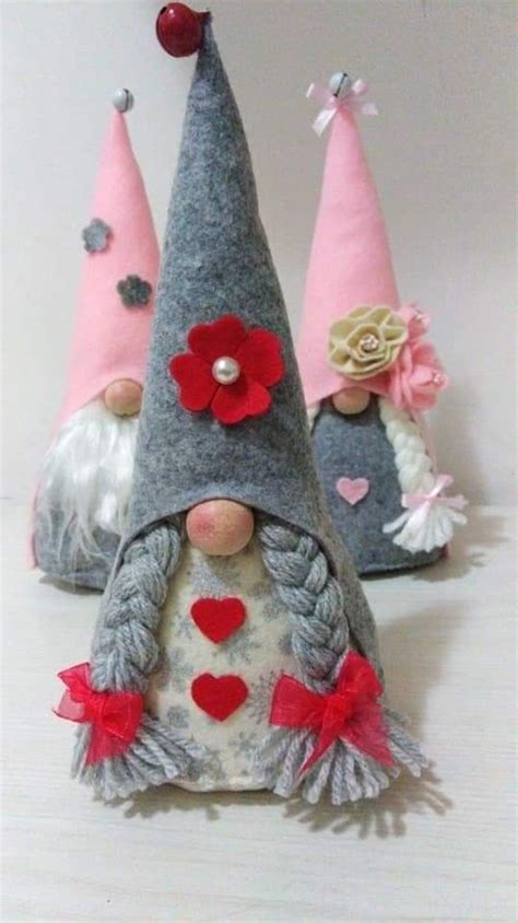 Three Gnomes With Hearts And Flowers On Their Heads Are Sitting Next To
