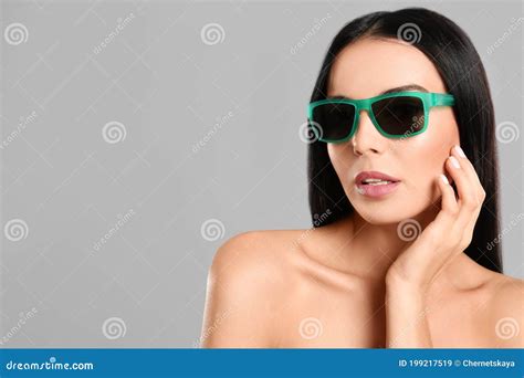 Beautiful Woman Wearing Sunglasses On Grey Background Space For Text