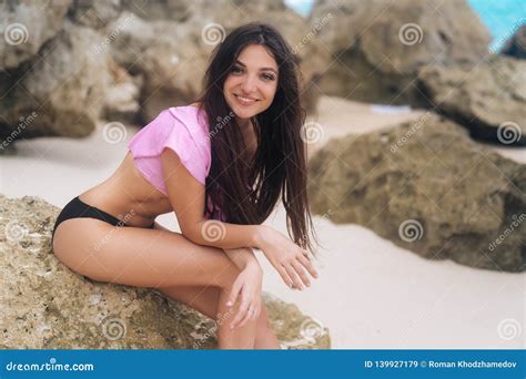 Portrait Of Sensual Girl In Swimsuit Relaxing At Beach With Big Stones On Background Stock Image