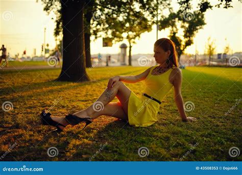 la belle fille dans une robe jaune s assied sur une herbe dans les faisceaux du soleil de