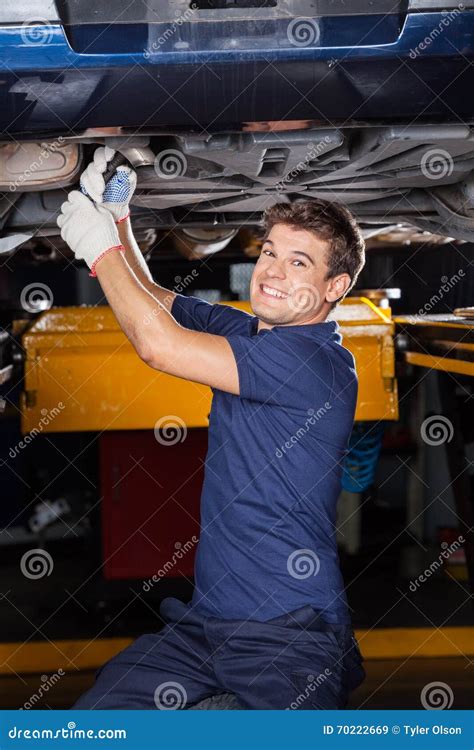 Happy Mechanic Working Underneath Lifted Car Stock Image Image Of