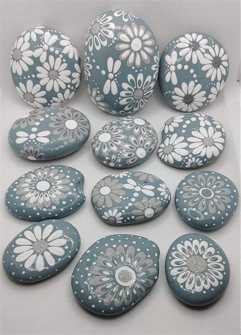 Several Blue And White Painted Rocks With Flowers On Them