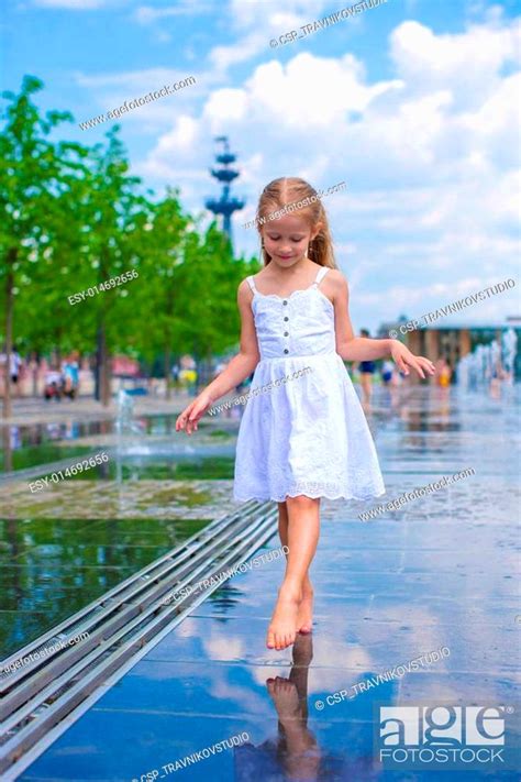 Little Cute Girl Walking In Open Street Fountain At Hot Sunny Day