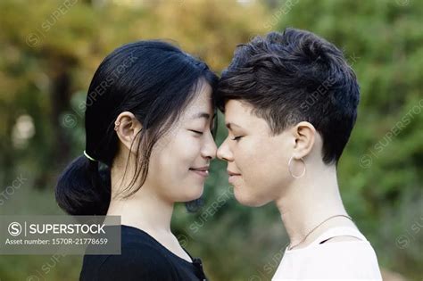 Close Up Of Smiling Lesbian Couple Standing Face To Face At Park Superstock