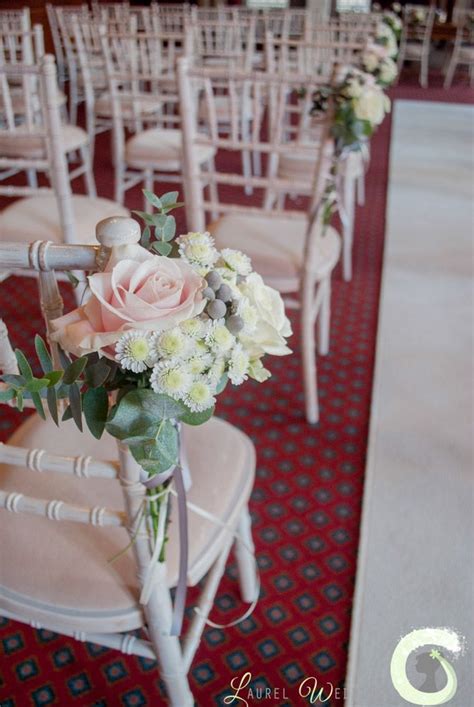 aisle chairs decorated with clusters of blush pink and ivory flowers pink winter weddings