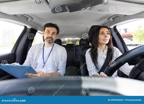 Unconfident Millennial Pretty Woman Driving Car With Instructor Stock