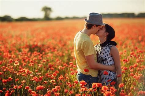 Premium Photo Couple Kissing In A Field Of Red Flowers