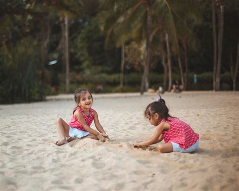 Premium Photo Twins Sisters Playing On Sand At Beach