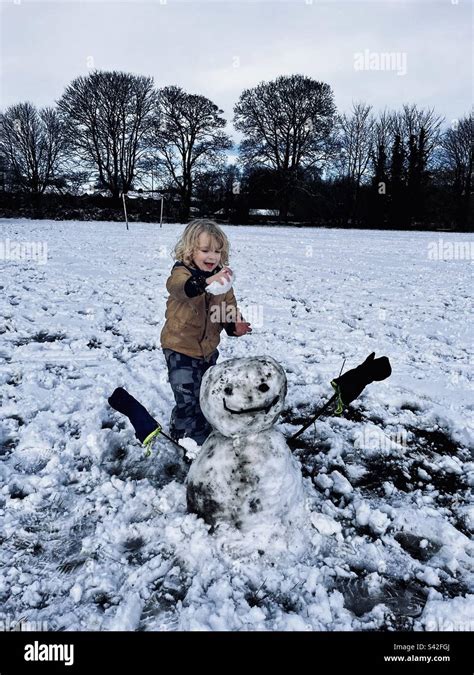 Child Building Snowman Stock Photo Alamy