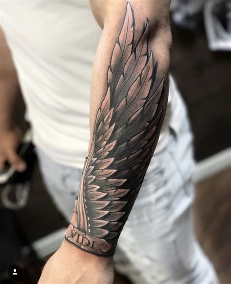 A Mans Arm With A Black And Grey Tattoo Design On The Left Arm