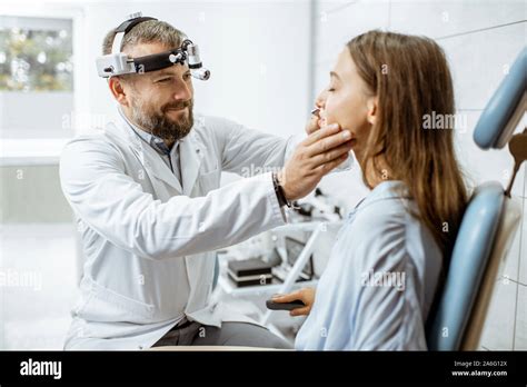Senior Otolaryngologist Examining Nose Of A Young Patient During A