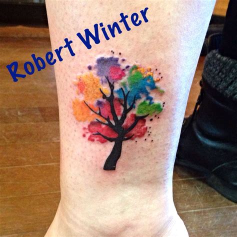 A Colorful Tree Tattoo On The Ankle With Words Robert Winter Above It