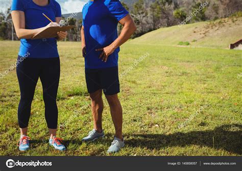 Female Trainer Instructing A Man In Bootcamp Stock Photo By