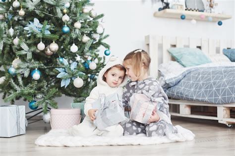 Dos Hermanas Pequeñas Abren Sus Regalos En El árbol De Navidad Por La