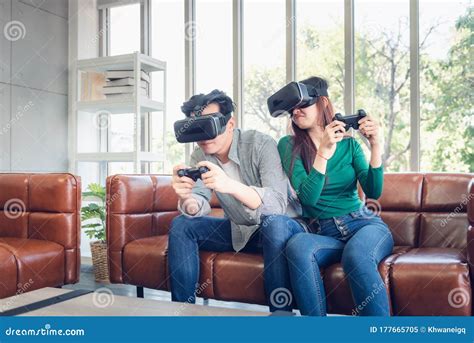 Young Couple Having Fun While Playing Virtual Reality Game Together In