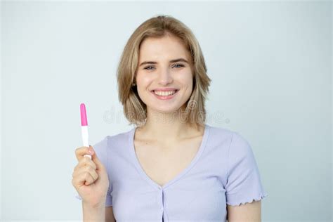 Happy Caucasian Young Woman Holding Pregnancy Test And Smilind Friendly