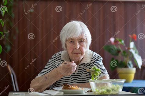 lonley solitary elderly woman having lunch alone sitting at the table at home lonely late life