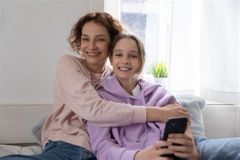 Portrait Of Smiling Mom And Teen Daughter Relax At Home Stock Image