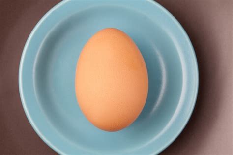 Un Huevo Crudo En Plato Blanco Sobre Fondo Blanco Desde La Vista
