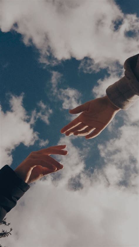 Two Hands Reaching For Each Other In The Sky
