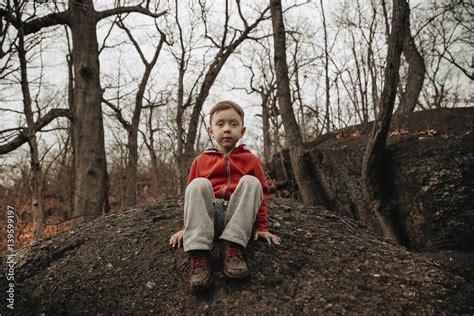 Child In A Dark Forest Sitting On A Rock Boy Alone In The Dusk Move