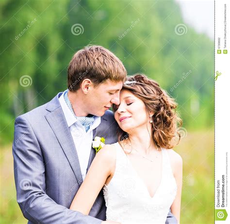 Beautiful Bride And Groom Standing In Grass And Kissing Wedding Couple