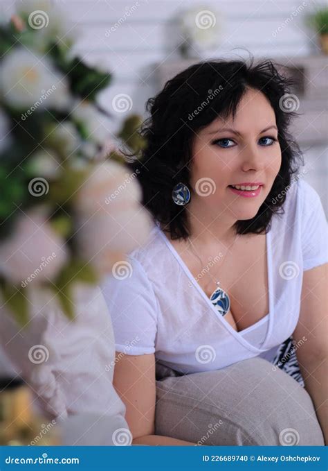 Long Legged Brunette Model In White Stockings And Miniskirt Shows Her Incredible Legs On Sofa