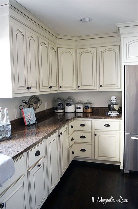 Placing light colored cabinets at eye level, and dark brown kitchen cabinets below naturally draws your eyes far from the dark on the light areas that seem more expansive. New Paint in Our Kitchen | 11 Magnolia Lane